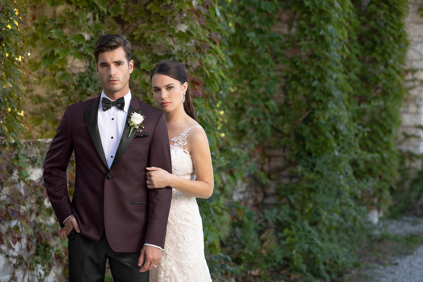 Man in a burgundy tuxedo standing with a women